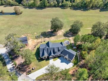 Stunning aerial view of custom home with large lawn, fire pit, and modern roofline at 441 Pumpkinvine Rd, Acworth, GA 30101
