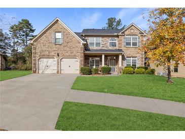 Charming brick two-story home with a well-manicured lawn and a two-car garage at 5619 Sawgrass Cir, Stonecrest, GA 30038