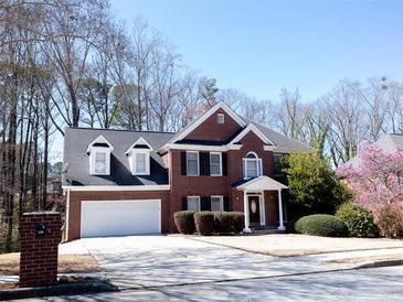 Charming two-story brick home with manicured landscaping, a two-car garage, and a welcoming front entrance at 100 Cross Creek Dr, Lilburn, GA 30047