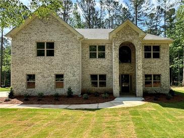 Attractive two-story home featuring a brick facade, manicured lawn, and mature trees at 123 Honey Creek Rd, Conyers, GA 30094