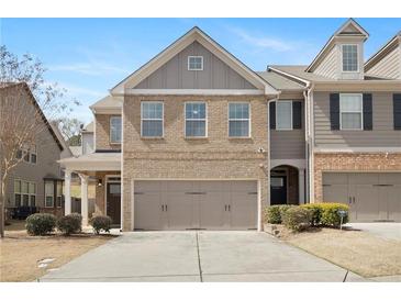 Charming two-story townhome featuring a brick facade and an attached two-car garage at 2308 Oakton Se Pl, Smyrna, GA 30082