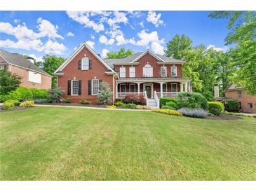 Beautiful brick two-story home with a lush lawn and welcoming front porch at 3070 Corsair Curv, Cumming, GA 30040