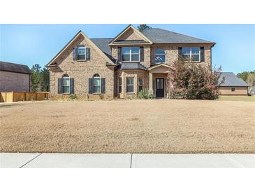 Charming brick home featuring a well-manicured lawn and inviting front entrance at 7347 Moss Stone Dr, Conyers, GA 30094