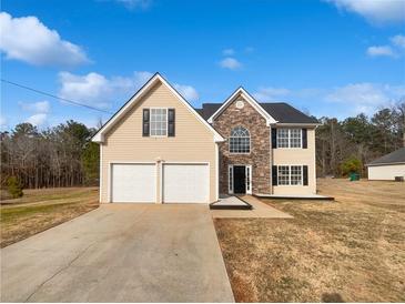 Charming two-story home featuring a stone facade, black shutters, and a two-car garage at 545 Zoie Ln, Palmetto, GA 30268