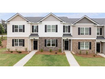 Charming townhome featuring a combination of brick and siding accents, complemented by black shutters and well-manicured lawns at 464 Reflection Dr # 22, Stockbridge, GA 30281