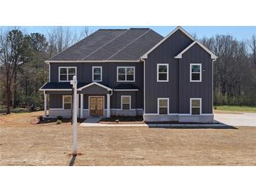 Newly constructed two-story home with gray siding, a gabled roof, and white-framed windows at 115 River Meadow Ln, Social Circle, GA 30025