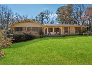 Charming one-story brick home featuring a well-manicured lawn and inviting front porch at 1198 Seminary Dr, Marietta, GA 30064