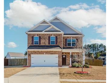 Charming brick two-story home with a well-manicured front yard and attached two-car garage at 3391 Meadow Grass Dr, Dacula, GA 30019