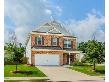 Charming two-story brick home featuring a two-car garage and a well-manicured front lawn at 3391 Meadow Grass Dr, Dacula, GA 30019
