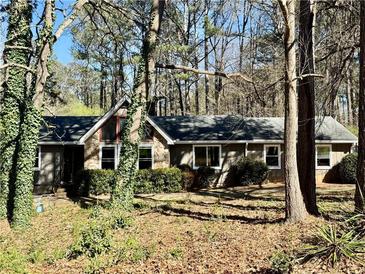 Charming single-story home featuring multiple windows and a lush surrounding landscape at 3252 Westbrook Trce, Lawrenceville, GA 30044