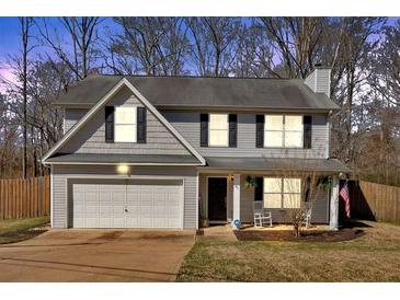 Charming two-story home with an attached garage and a cozy front porch featuring rocking chairs at 81 Summer Creek Dr, Dallas, GA 30157