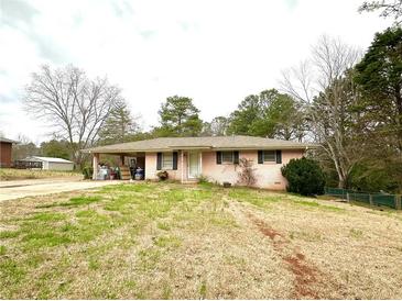 Charming single-story brick home featuring a covered carport and a spacious front yard at 3110 Pope Rd, Douglasville, GA 30135