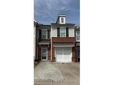 Charming townhome with brick and siding exterior, featuring a two-car garage and well-maintained lawn at 3191 Creston Park Ct, Duluth, GA 30096