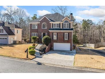 Charming brick home with well-manicured lawn and two-car garage at 1039 Ashfern Walk, Woodstock, GA 30189