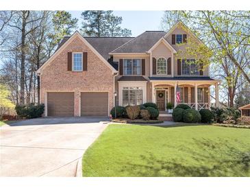 Beautiful two-story home with a brick facade, a well-manicured lawn, and a two-car garage at 5383 Fawn Meadow Ln, Powder Springs, GA 30127