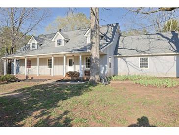 Charming single-story home featuring a covered porch, dormer windows, and a well-maintained front lawn at 75 Price Dr, Locust Grove, GA 30248