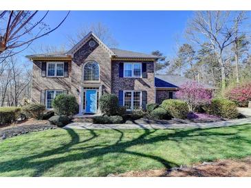 Inviting two-story brick home featuring a well-manicured lawn and vibrant landscaping at 2030 Habersham Trce, Cumming, GA 30041