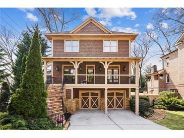 Charming two-story home with a welcoming front porch and two-car garage, showcasing classic architectural details at 1211 Thornwell Ne Dr, Brookhaven, GA 30319