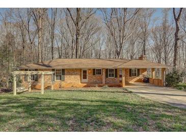 Charming ranch-style home featuring a brick facade, covered carport, and inviting front yard space at 2870 Carla Nw Dr, Kennesaw, GA 30144