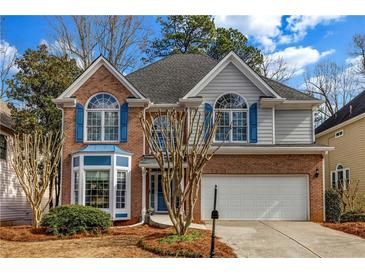 Charming two-story home with a brick and siding exterior, showcasing blue shutters and well-maintained landscaping at 3369 Arbor Path Dr, Atlanta, GA 30340