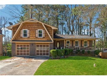 Charming two-story home with a well-manicured front lawn, garage, and inviting porch at 4453 Abingdon Dr, Stone Mountain, GA 30083