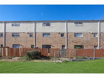 Townhome exterior featuring a combination of brick and siding, fenced yard and green grass at 4701 Flat Shoals Rd # 49C, Union City, GA 30291