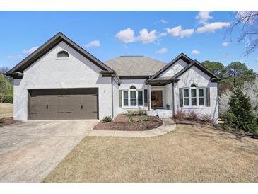 Charming one-story brick home featuring a two-car garage and well-manicured lawn at 1090 Compton Way, Suwanee, GA 30024