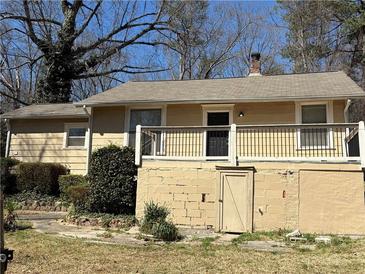 Quaint single-story home showcasing neutral siding, a chimney, and a welcoming front porch entrance at 1415 Dodson Sw Dr, Atlanta, GA 30311
