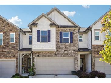 Charming townhome with brick and siding, featuring a two-car garage and stylish blue shutters at 1484 Ben Park Way, Grayson, GA 30017