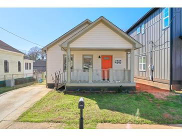 Charming home featuring a quaint front porch, a well-maintained lawn, and an orange front door at 160 Vine Nw St, Atlanta, GA 30314