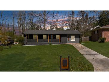 Charming single-story home features a spacious front yard and inviting covered front porch at 282 Oak Se Dr, Atlanta, GA 30354