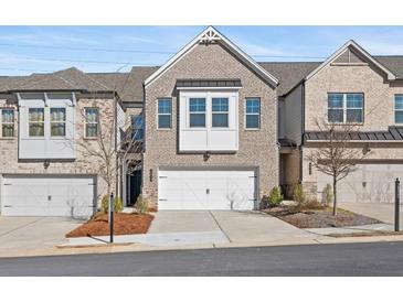 Charming brick townhome with a two-car garage and inviting curb appeal at 2855 Mcmurtry St, Cumming, GA 30041