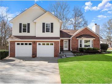 Charming two-story home with a brick and vinyl exterior and well-maintained lawn at 6920 Greenfield Ln, Cumming, GA 30028