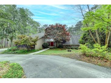 Scenic view of home surrounded by lush trees, a circular driveway, and well-maintained landscaping at 311 Maranatha Trl, Lawrenceville, GA 30045