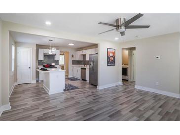 Modern kitchen with stainless steel appliances, white cabinetry, and an island, seamlessly flowing into an open-concept living space at 1256 Elizabeth Sw Ave, Atlanta, GA 30310