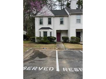 Charming townhome with a lovely yard, classic white siding, and reserved parking spaces right out front at 122 Belmonte Sw Dr, Atlanta, GA 30311
