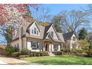 Charming two-story home featuring a lush lawn, beautiful landscaping, and classic architectural details at 218 Garland Ave, Decatur, GA 30030