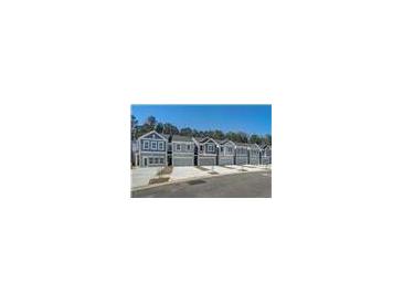 Row of gray townhomes with two-car garages and landscaped front yards on a sunny day at 5154 Longview Run, Decatur, GA 30035