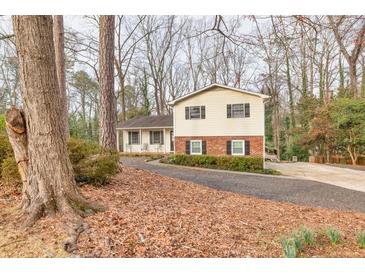 Charming two-story home with a blend of siding and brick and a long driveway at 1417 Hickory Sw Dr, Lilburn, GA 30047