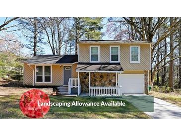 Charming two-story home with stone accents, front porch, well-manicured lawn, and attached garage at 1946 Taffeta Trl, Lithonia, GA 30058