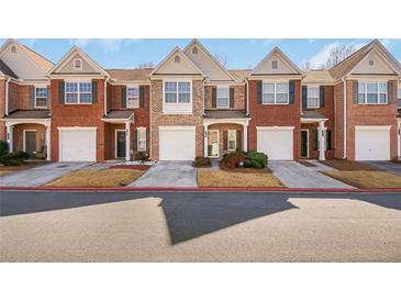 Charming townhome exterior with brick facade, attached garage, and well-maintained landscaping at 2411 Heritage Park Nw Cir # 14, Kennesaw, GA 30144