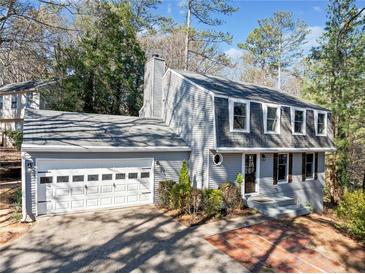 Charming two-story home featuring gray siding, a brick walkway, and a two-car garage at 195 Sailwind Ct, Roswell, GA 30076