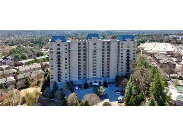 A luxury condominium building featuring a blue roof, multiple stories, and beautiful surrounding landscaping at 2700 Paces Ferry Se Rd # 302, Atlanta, GA 30339