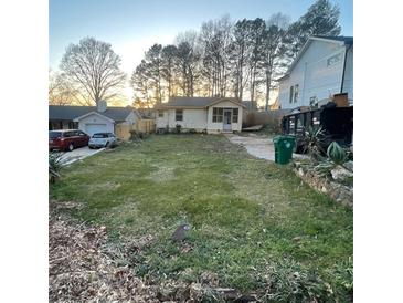 Cozy single-story home with a flat lawn and driveway and mature trees at 514 Glendale Rd, Scottdale, GA 30079