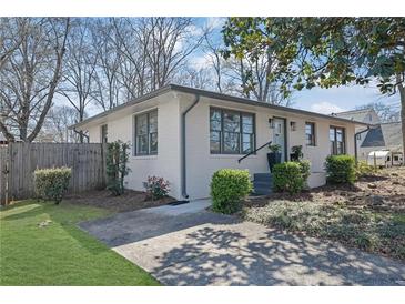 Charming painted brick home with gray trim, green lawn, and manicured landscaping at 965 Carr Nw St, Atlanta, GA 30318