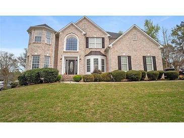 Charming brick home featuring well-manicured landscaping and a welcoming front entrance at 1536 Granby Ln, Locust Grove, GA 30248