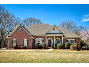 Beautiful brick home with a well-manicured lawn and lovely landscaping at 8005 Sweet Creek Rd, Johns Creek, GA 30097