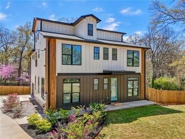 Striking new construction featuring a modern farmhouse style with a manicured lawn, and black framed windows at 3087 Alston Dr, Decatur, GA 30032
