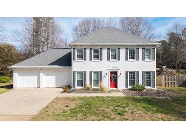 Charming white home with a red door, gray shutters, and a well-manicured front yard at 1011 Dogwood Forest Ne Dr, Marietta, GA 30068