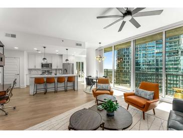 Bright open floor plan featuring a modern kitchen, dining area, and comfortable living space with floor-to-ceiling windows at 1080 Peachtree Ne St # 1909, Atlanta, GA 30309